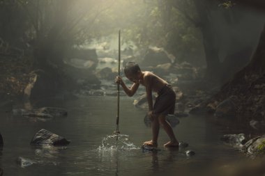 Fisher çocuk avcı creek ormanda.
