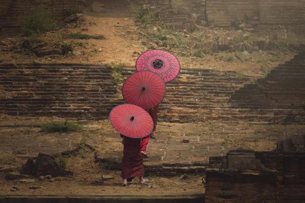 Yeni başlayanlar ve pagoda için yürüyüş kırmızı şemsiye tutan arkadaşlar