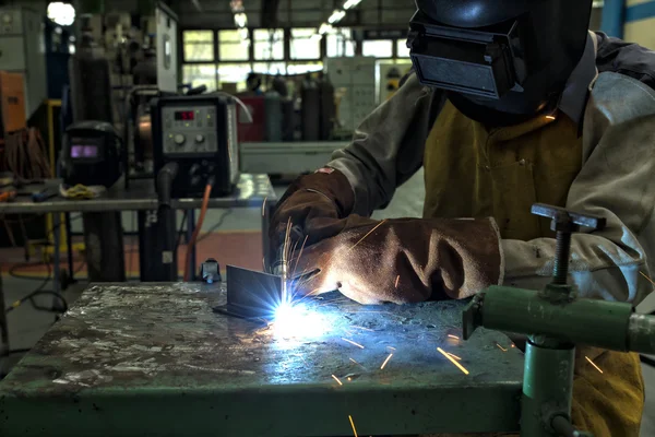 worker welding with sparks