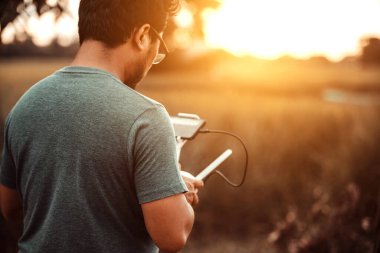 İHA kontrolörü, insansız hava aracını uçuruyor.