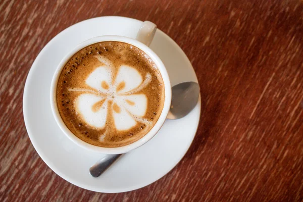 Een kopje koffie met hartje patroon in een witte beker — Stockfoto