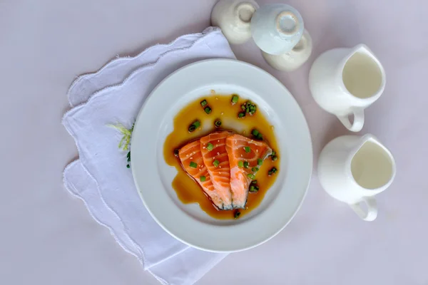 Salmon fillet with sauce on white dish — Stock Photo, Image