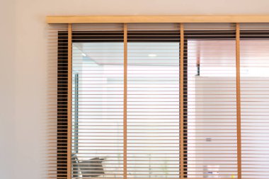 Modern bir iç mekanda ayarlanabilir ahşap perdelerin işlevselliğini ve stilini keşfedin..