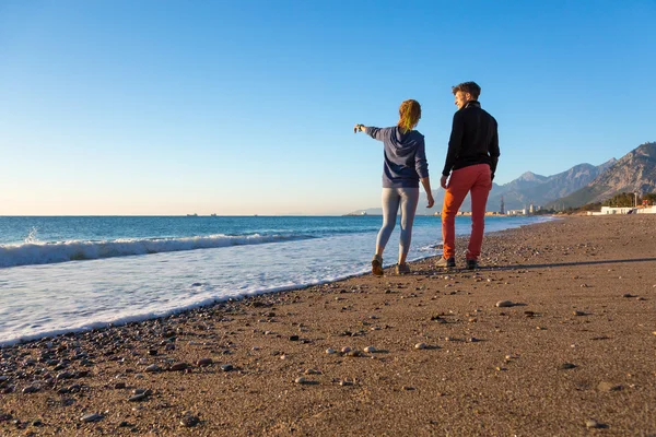 Hombre y mujer caminando por la playa y disfrutando de vistas al mar —  Fotos de Stock