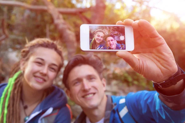 Joven familia tomando fotos al aire libre con teléfono móvil — Foto de Stock