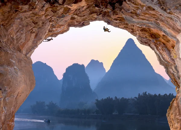 Caverna alta profunda escaladores extremos no nascer do sol na China Montanhas — Fotografia de Stock