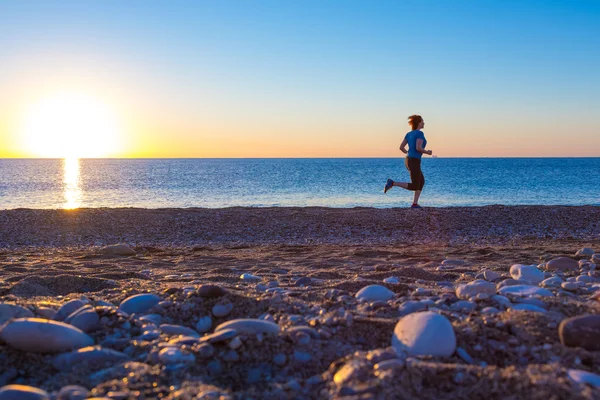 Siluett av kvinna Jogger på Ocean Beach på Sunrise — Stockfoto