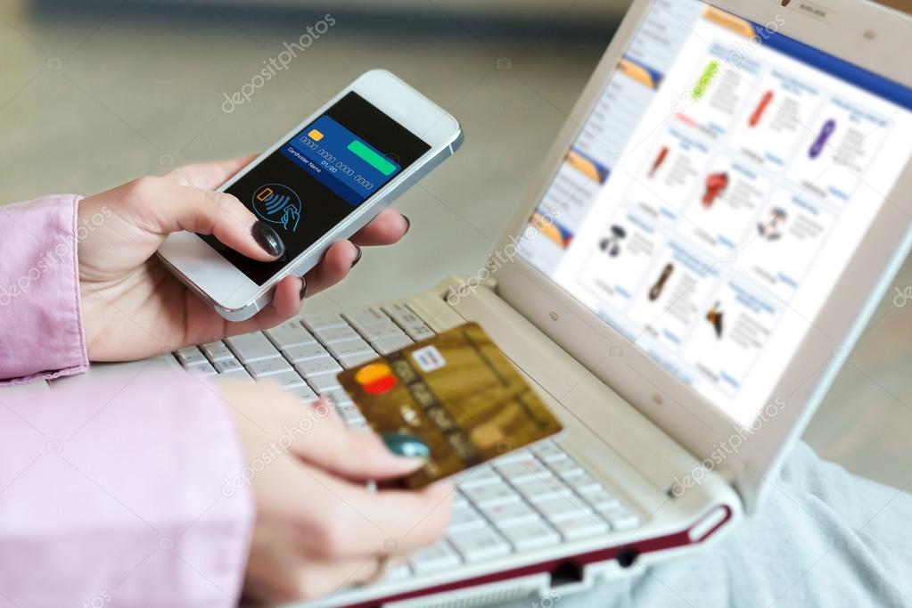 Hands of Woman shopping on-line holding credit Card and Telephone