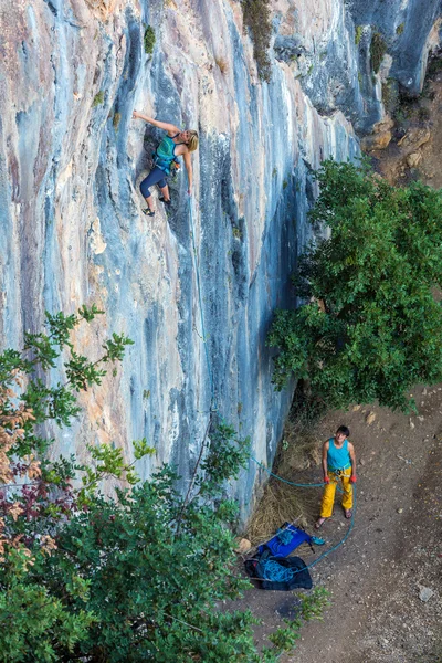 Zwei Bergsteiger arbeiten zu zweit an senkrechter Felswand — Stockfoto