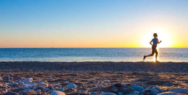 Silhuett av idrottskvinna på Ocean Beach på Sunrise — Stockfoto