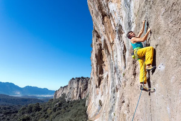 Maduro macho extremo escalador moviéndose hacia arriba en la pared rocosa —  Fotos de Stock