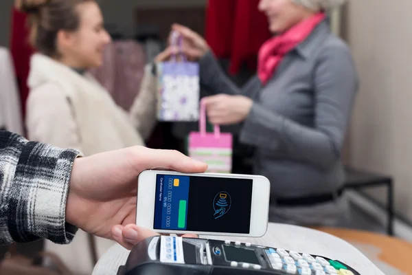 Near Field Communication - Man completing mobile Payment Woman shopping — Stock Photo, Image