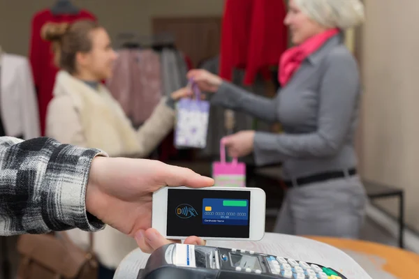 In de buurt van de mededeling van het gebied - Man voltooiing van mobiele betaling vrouw winkelen — Stockfoto