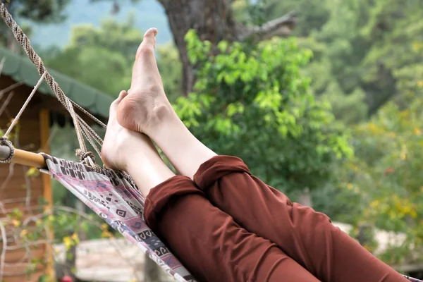 Person relaxing lying in Hammock at rural cottage garden — Stock Photo, Image