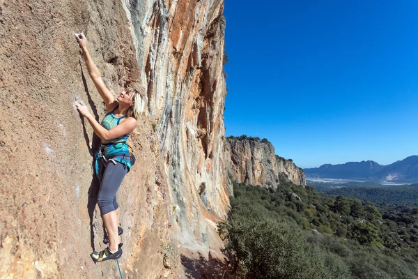 Vrouwelijke extreme klimmer opknoping op hoge verticale Rock — Stockfoto