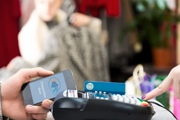 Man completing mobile Payment at Store Cashiers Desk with Terminal — Stock Photo, Image