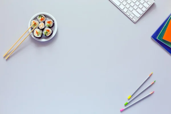 Vista superior del lugar de trabajo de oficina en escritorio gris con sushi —  Fotos de Stock