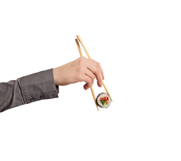 Mano de mujer sosteniendo rollo de sushi con palillos fondo blanco — Foto de Stock