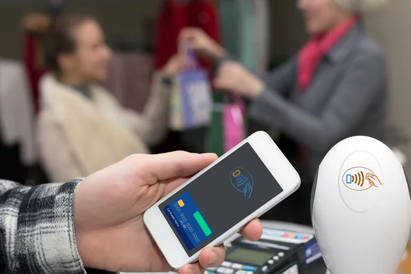 Man completing mobile Payment at Store Cashiers Desk with Terminal — Stock Photo, Image