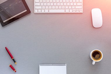 Not defteri, bilgisayar ve kahve fincanı olan ofis masası.