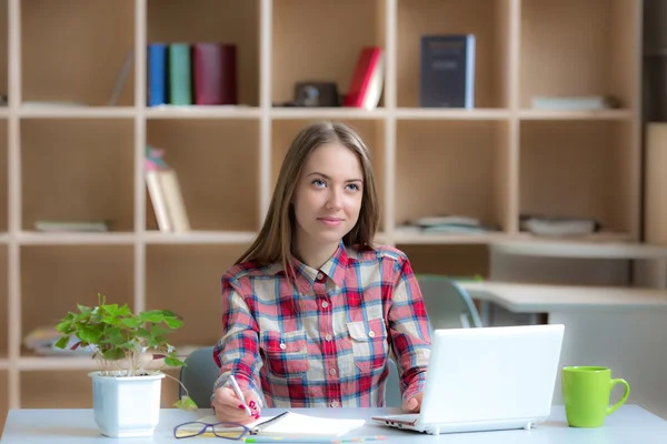Young female Freelancer Professional working at desk in warm interior — Stockfoto