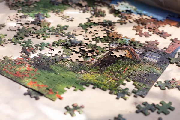 Un mucchio di elementi puzzle colorati sulla superficie beige — Foto Stock