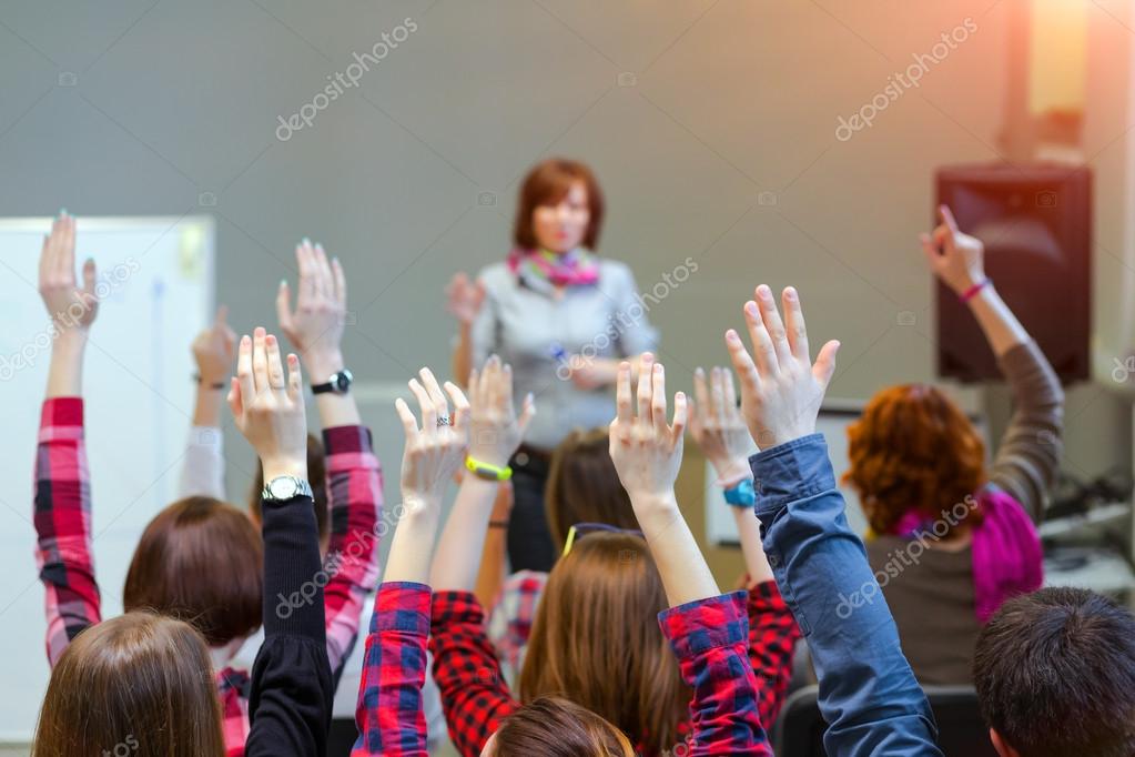 Estudiantes activos levantando brazos listos para responder a la