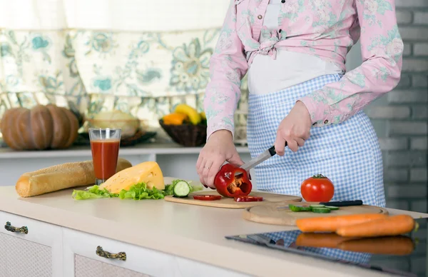 Corpo e mãos de mulher cortando legumes na cozinha doméstica — Fotografia de Stock