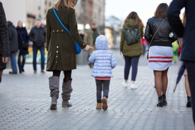 Anne ve kızı şehir sokak kalabalığın arasında yürürken