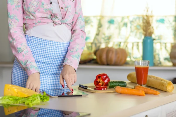 Woman cooking Salad using Recipe on screen of Tablet — Stock Photo, Image