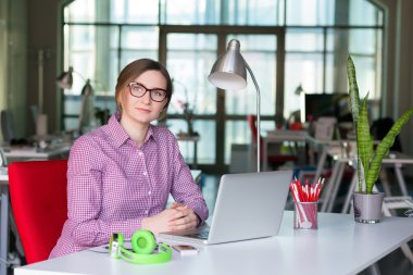 Office masada oturan rahat giyim gülümseyen iş kadını