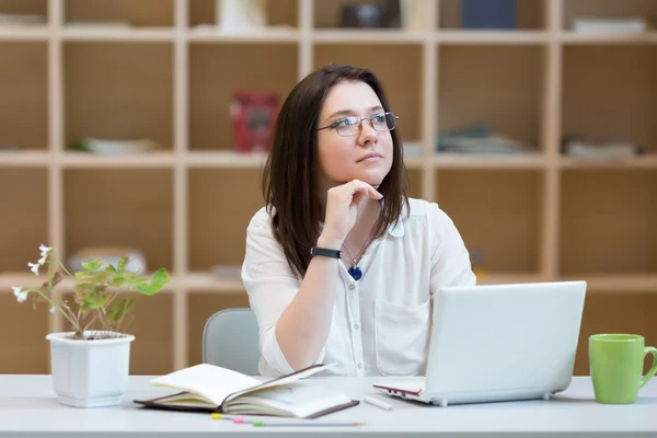 Mujer joven pensando en relajado Postura en el lugar de trabajo —  Fotos de Stock