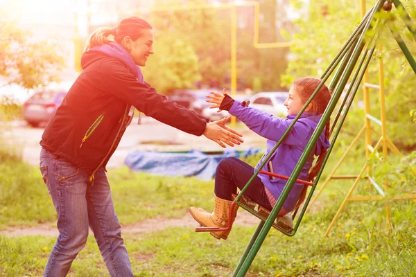 Young Mother Riding Little Daughter on Seesaw in Spring Park — Stock Photo, Image