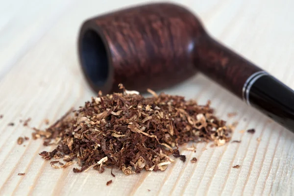 Dosis de tabaco seco y tubería sobre fondo de madera — Foto de Stock