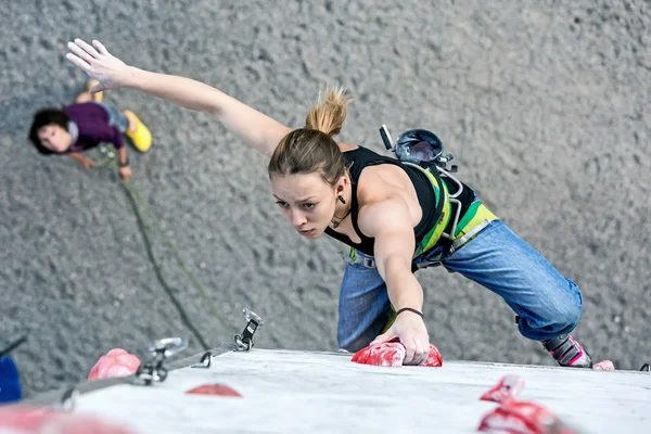 Cute female Athlete hanging on climbing Wall — Stock Photo, Image