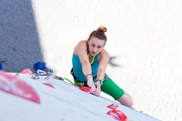 Atleta feminina faz movimento duro na parede de escalada — Fotografia de Stock