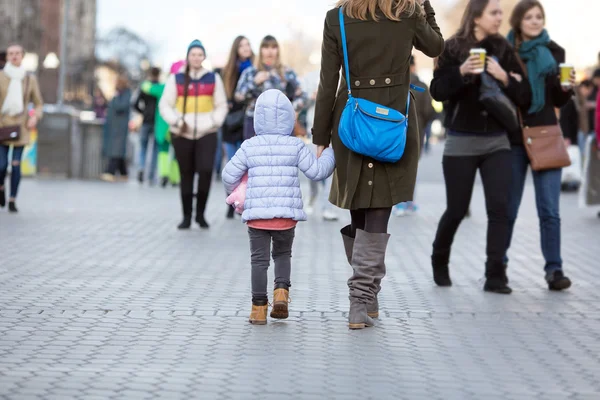 Мать и дочь гуляют по Сити-стрит среди толпы — стоковое фото