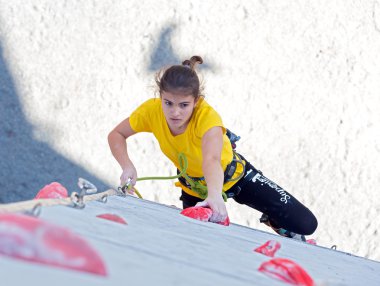 Genç kadın atlet duvar tırmanma üzerinde sert hareket yapar