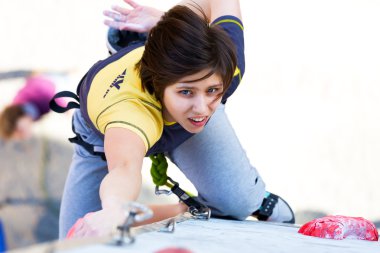 Sevimli kadın atlet duvar tırmanma üzerinde asılı