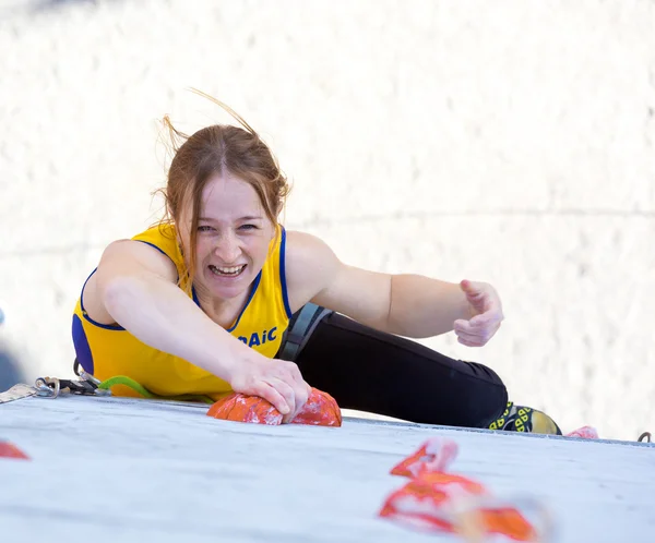 Atleta feminina faz movimento duro na parede de escalada — Fotografia de Stock