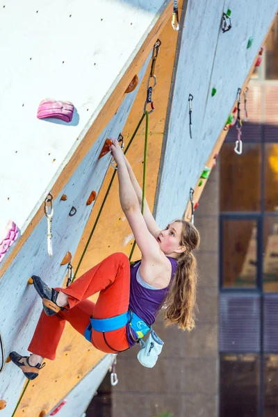 Júnior atleta femenina hace un movimiento duro en la pared de escalada — Foto de Stock