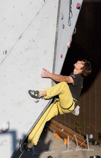 Escalador colgando de la pared de escalada en competiciones —  Fotos de Stock