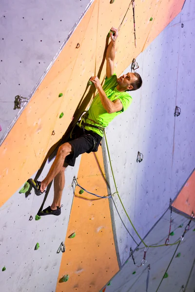 Escalador tentando alcançar um porão na parede de escalada — Fotografia de Stock