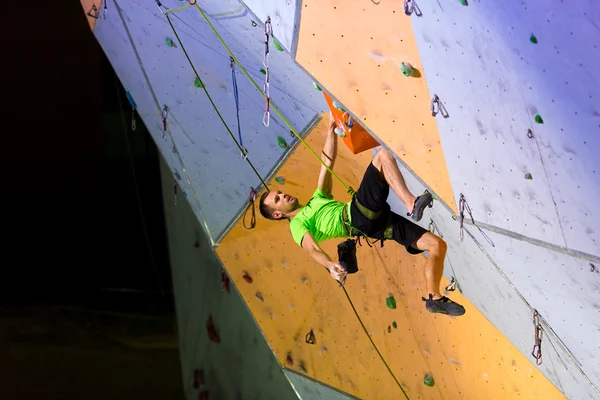 Escalador colgando en la pared de escalada — Foto de Stock