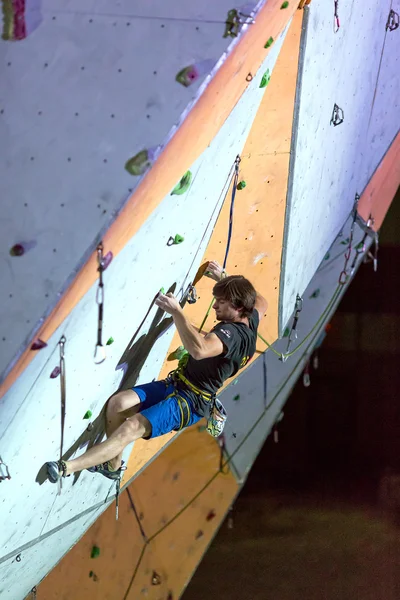 Escalador colgando en la pared de escalada — Foto de Stock