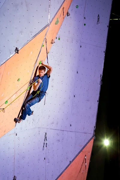 Escalador tratando de arreglar una cuerda en la pared de escalada —  Fotos de Stock