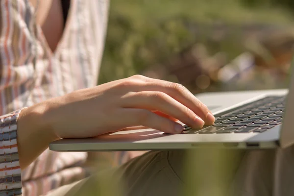 Женщина работает на открытом воздухе с ноутбуком — стоковое фото