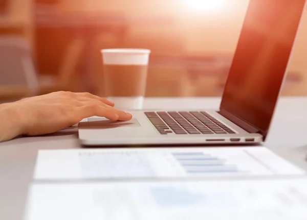 Uomo che lavora sul computer portatile in ambiente accogliente con caffè — Foto Stock