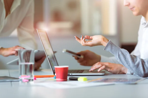 Équipe discutant du projet pointant sur l'ordinateur au bureau moderne — Photo