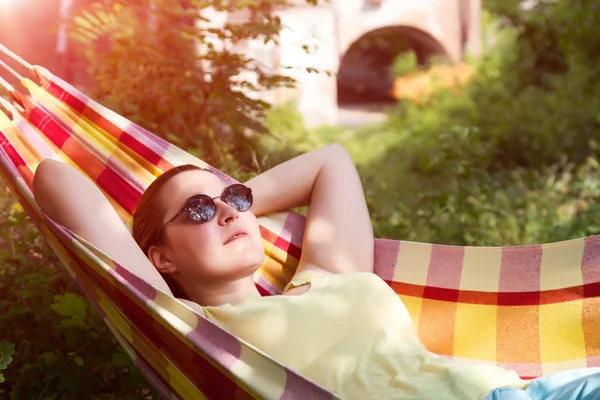 Person mit Sonnenbrille entspannt sich in der Buckelpiste im Sommergarten — Stockfoto